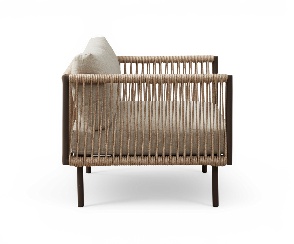 Sidevisning af beige loungestol med rebflettede sider og pude, frilagt på hvid baggrund.