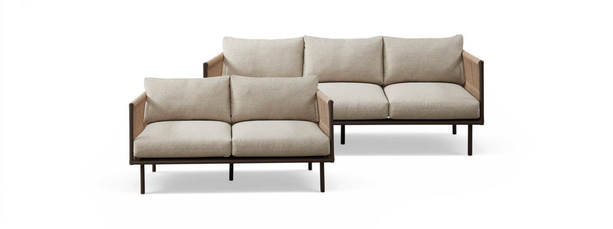 To beige modulsofaer med slanke mørke ben og vævede sidepaneler, frontvisning mod hvid baggrund.
