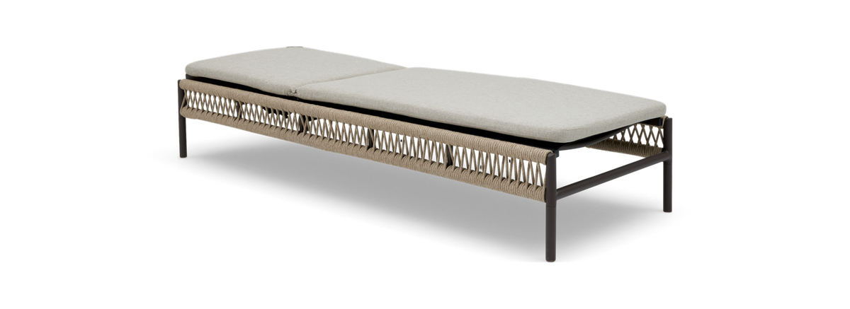 Lang daybed/bænk i sort metal med flettet reb og lysegrå hynder, frilagt.