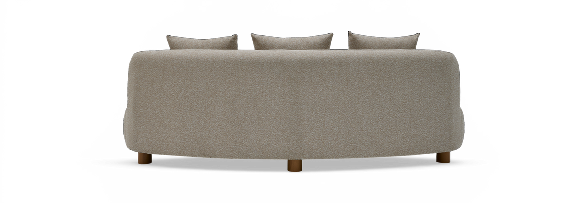 Beigefarvet, buet sofa set bagfra med tre rygpuder og træben, frilagt mod sort baggrund.