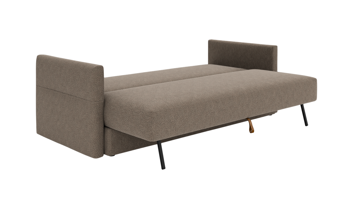 Beige sovesofa med armlæn i begge ender og sorte ben, fotograferet skråt forfra på frilægning.