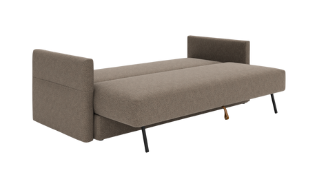 Beige sovesofa med armlæn i begge ender og sorte ben, fotograferet skråt forfra på frilægning.