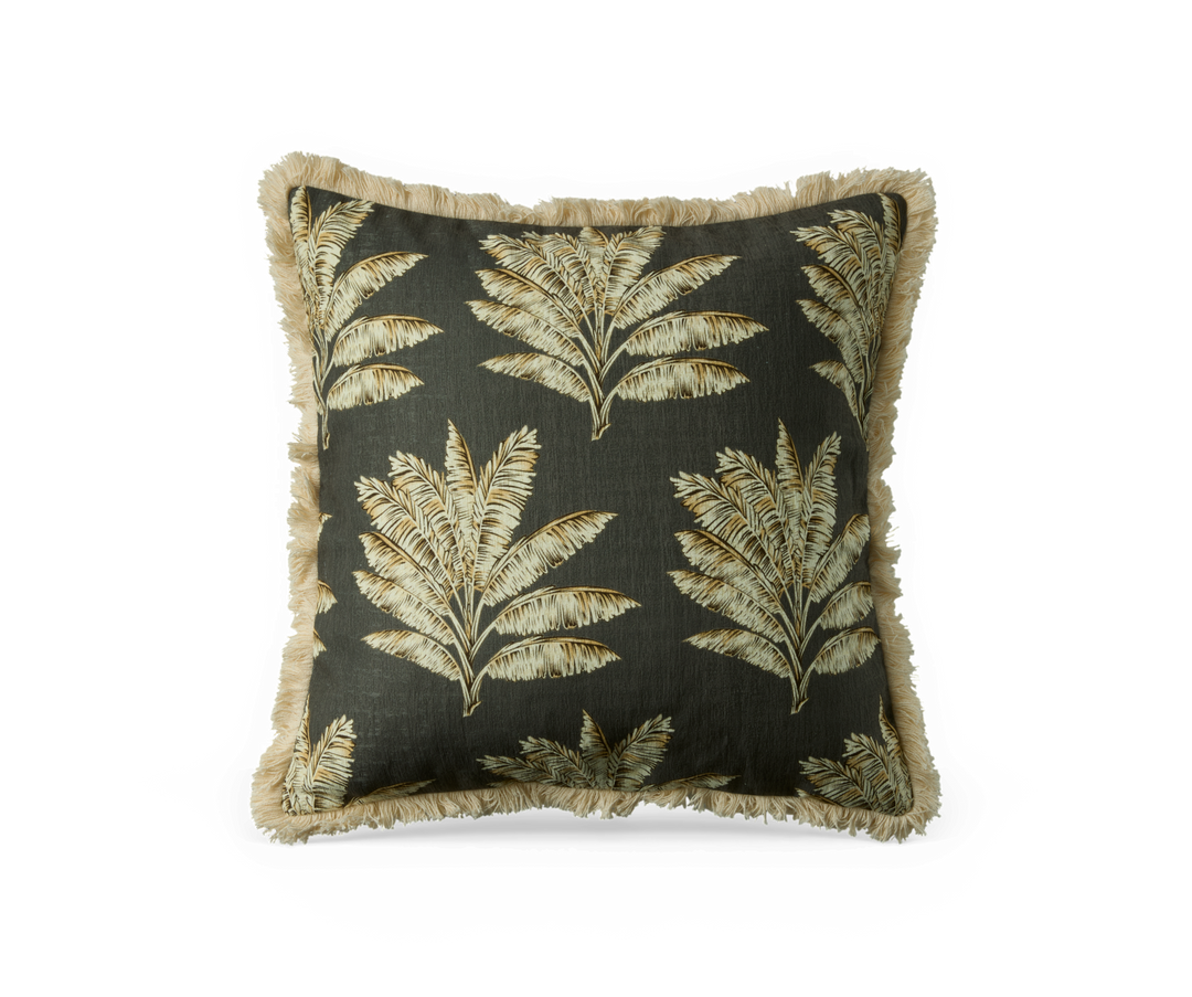 Kvadratisk pyntepude med mørkegrøn bund, beige palmebladsmønster og frynset kant.