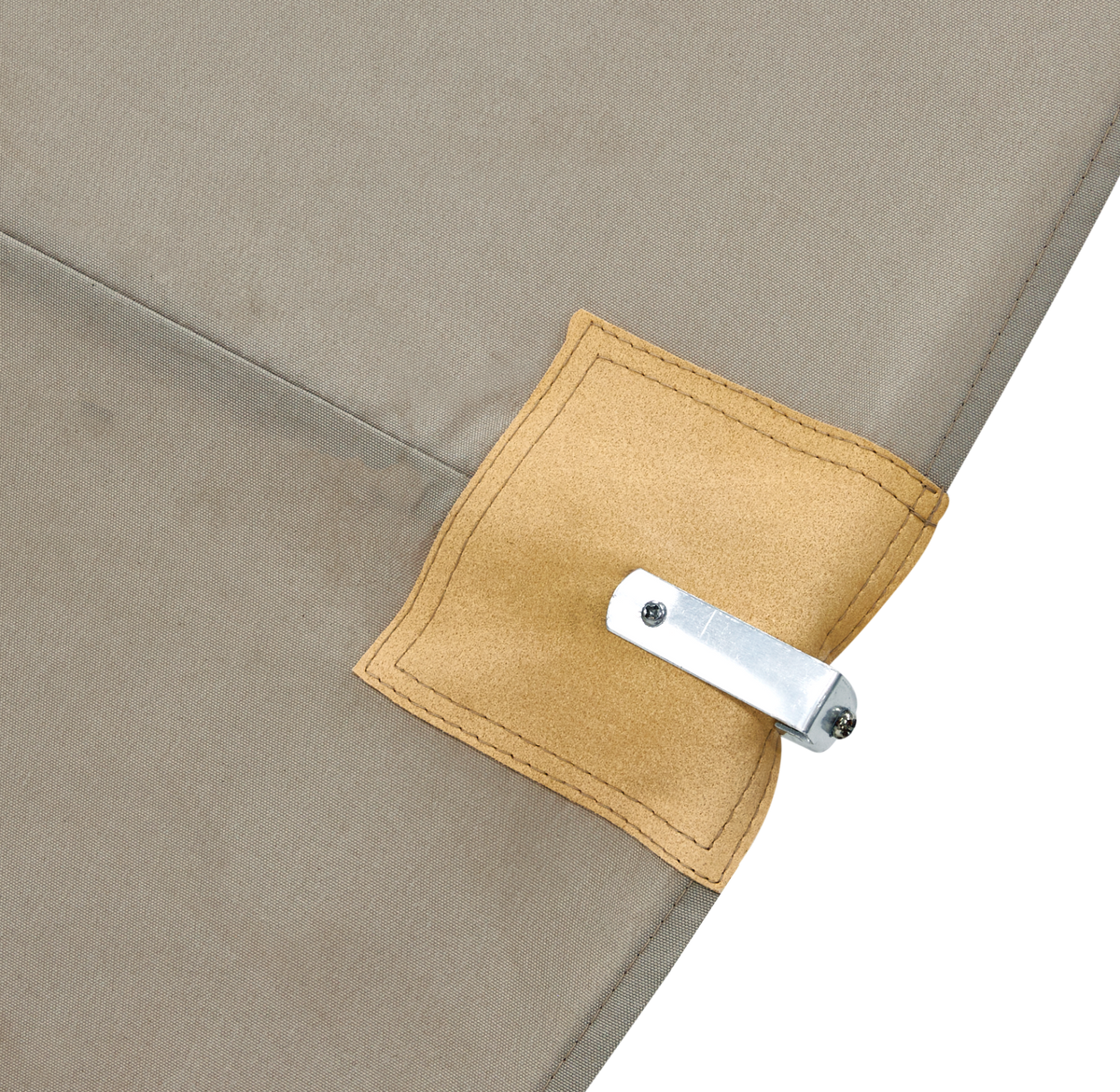 Nærbillede af beige stof med syet firkantet læderflap og monteret metalklemme.