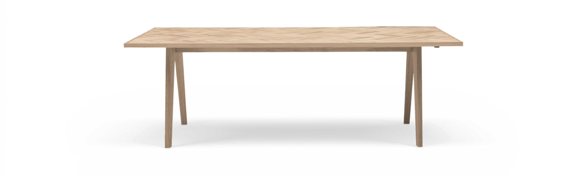 Rektangulært spisebord i lys eg med sildebenmønster på bordpladen og fire slanke, tilspidsede ben, frilagt produktbillede.
