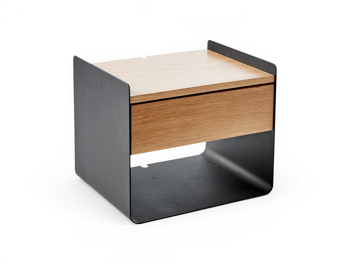 Lille sidebord/sengebord i sort stål med egetop og skuffe, frilagt mod hvid baggrund.
