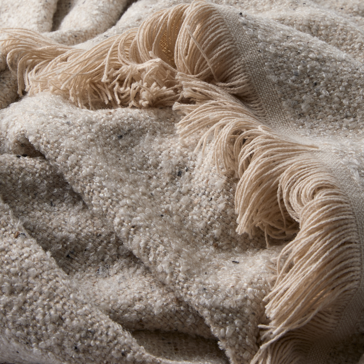 Nærbillede af beige, tekstureret plaid med frynser.