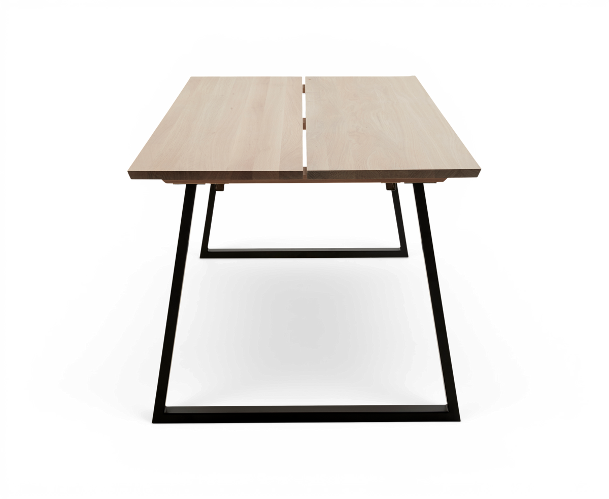 Rektangulært spisebord i lys eg med delt bordplade og sorte metalben, frilagt produktfoto set forfra.