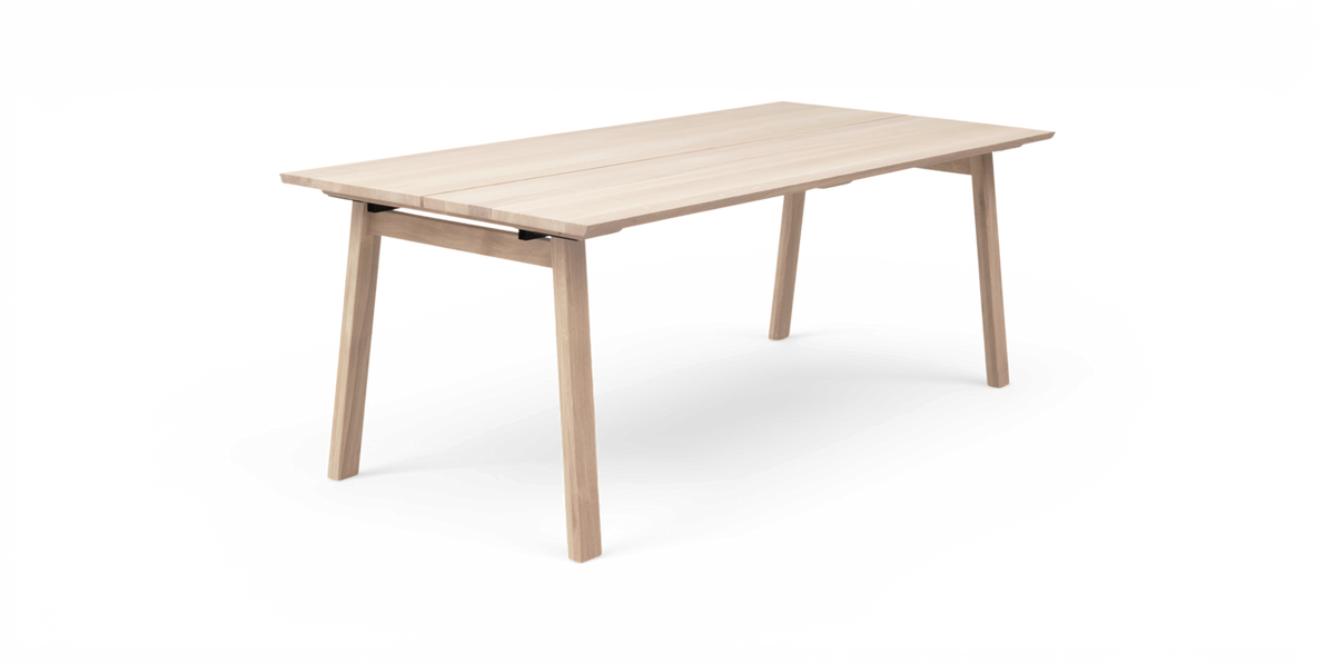 Lyst egetræsfarvet rektangulært spisebord i minimalistisk design frilagt på hvid baggrund, set i skrå frontvinkel.