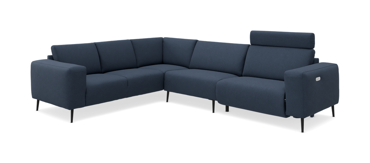 Mørkeblå L‑formet modulsofa med justerbart nakkestøtte og slanke sorte ben, frilagt på hvid baggrund.