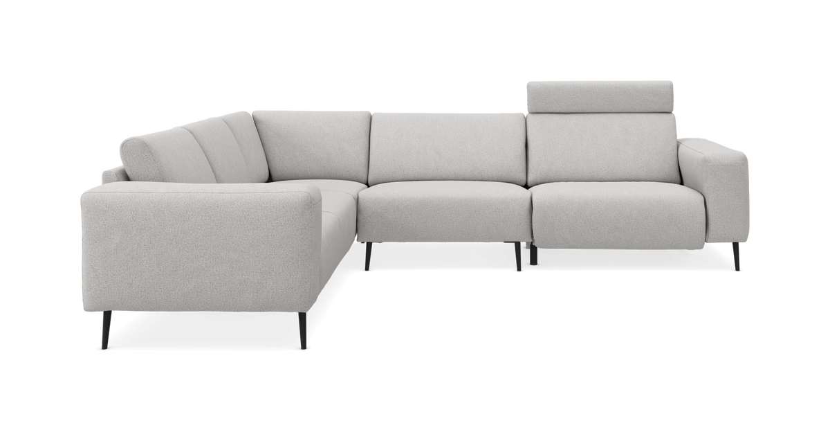 L‑formet lysegrå modulsofa med høje slanke sorte ben og justerbar nakkestøtte på højre del, fritlagt mod hvid baggrund.