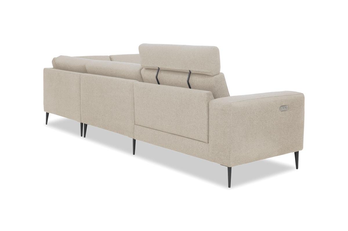 Beige modulsofa set skråt bagfra med justerbar nakkestøtte og slanke sorte ben, frilagt på hvid baggrund; strømkontakt på armlænet.