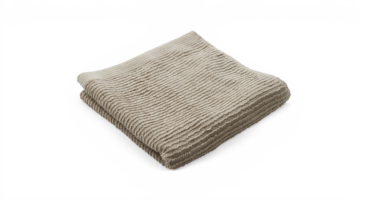 Sammenfoldet beige håndklæde med rillet struktur på hvid baggrund.