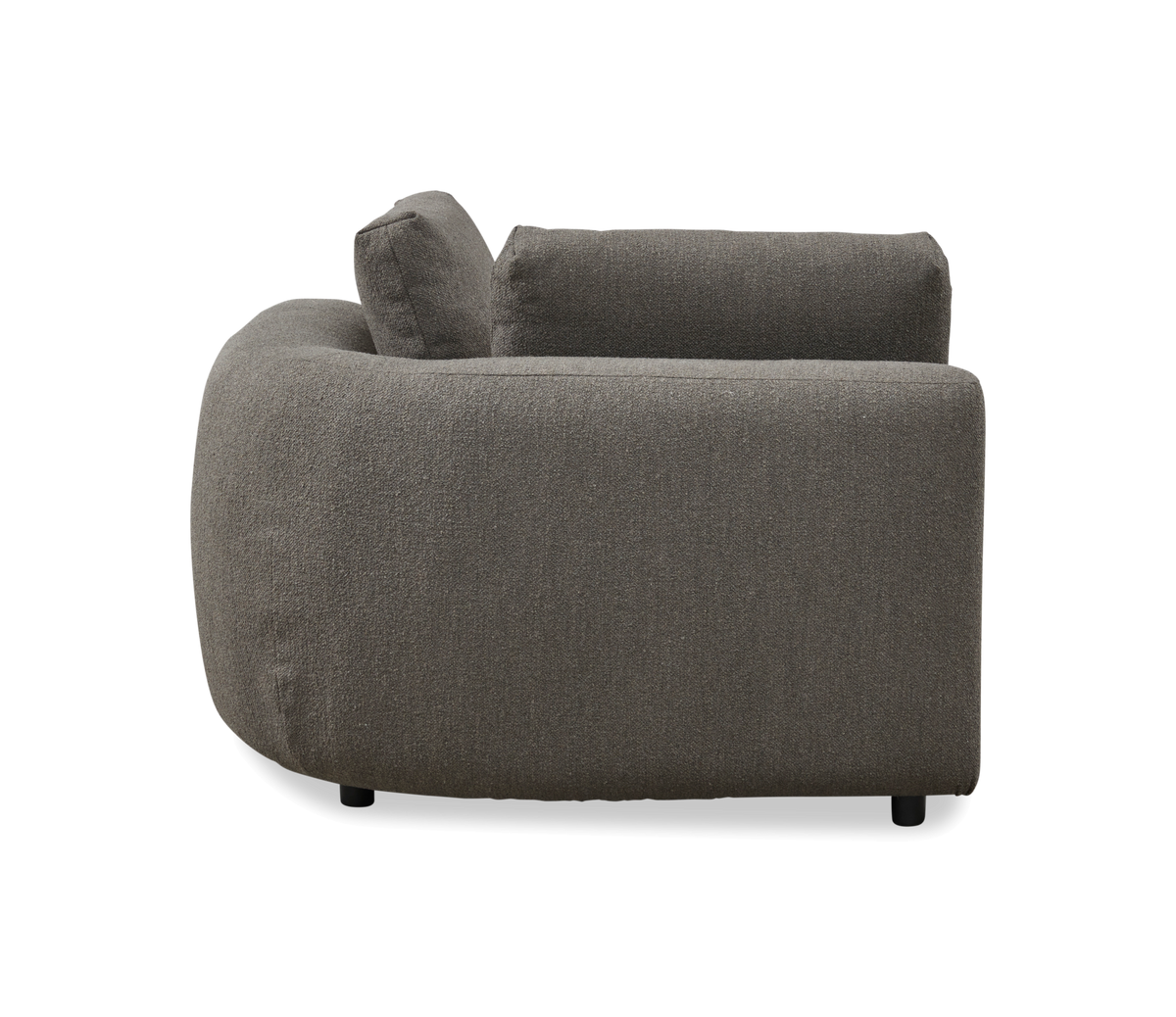 Sidevisning af en grå polstret sofa med afrundet armlæn på hvid studiebaggrund.