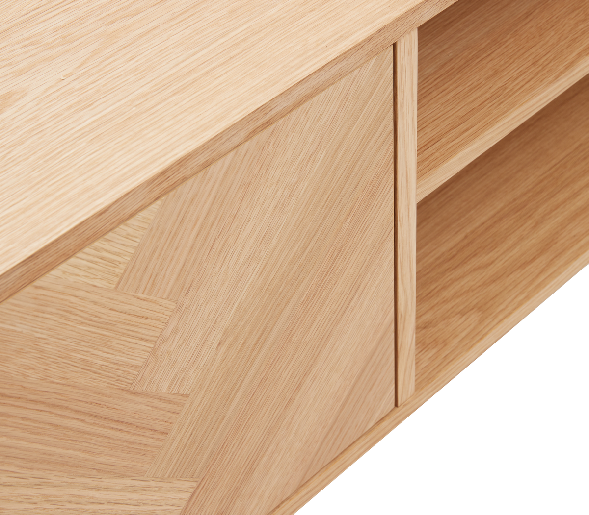Nærbillede af et sideboard i lys eg med skydedør og åbne hylder.