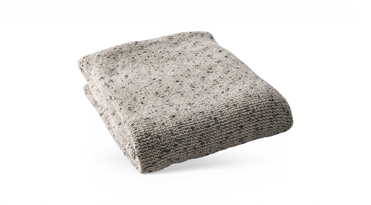 Sammenfoldet strikket plaid i lys beige meleret.