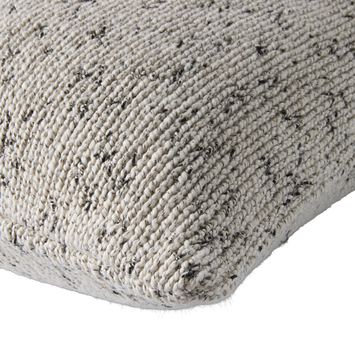 Nærbillede af beige vævet pude med sort melering.