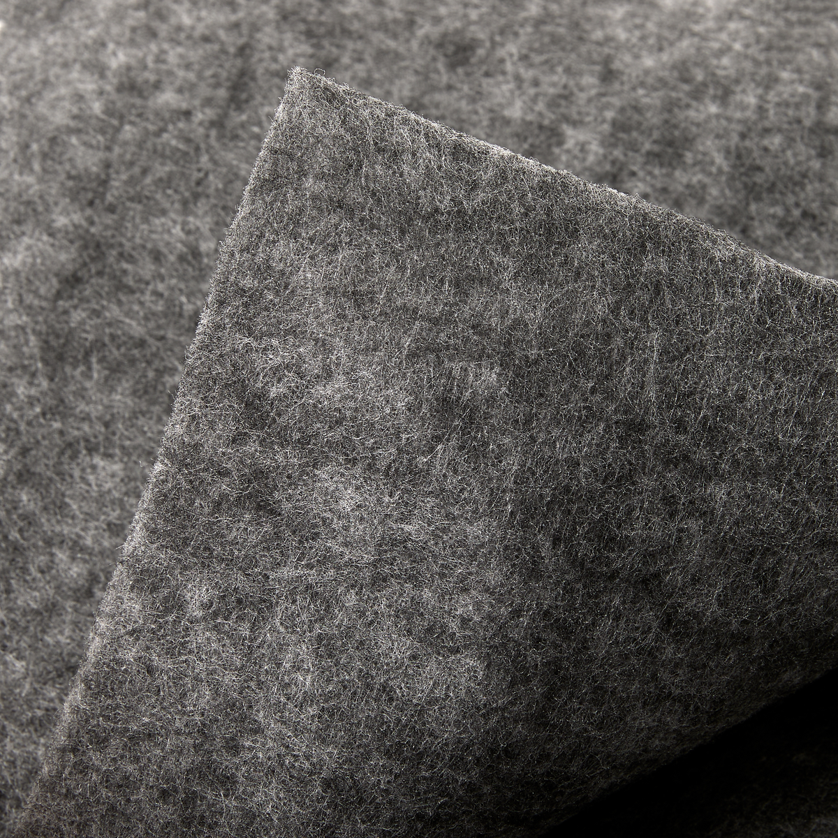 Close-up af gråt filtmateriale, lag af stof med blød, fnugget tekstur.