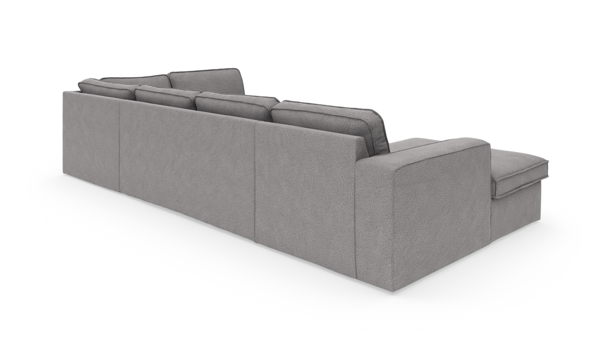 Grå modulsofa med chaiselong set bagfra i studie.