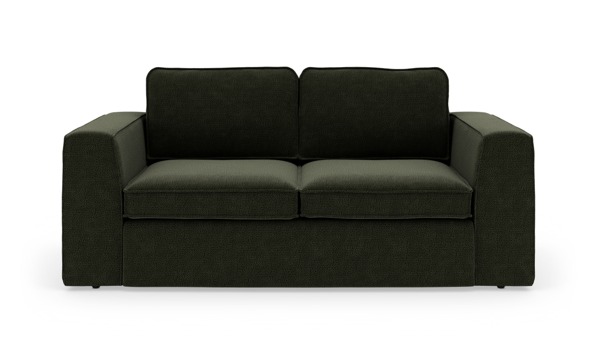 Mørkegrøn sofa med brede armlæn, frilagt på hvid baggrund.