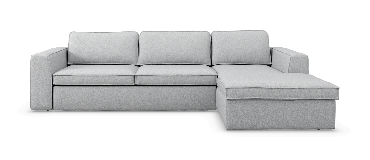 Lysegrå hjørnesofa med chaiselong på højre side, enkel og moderne.