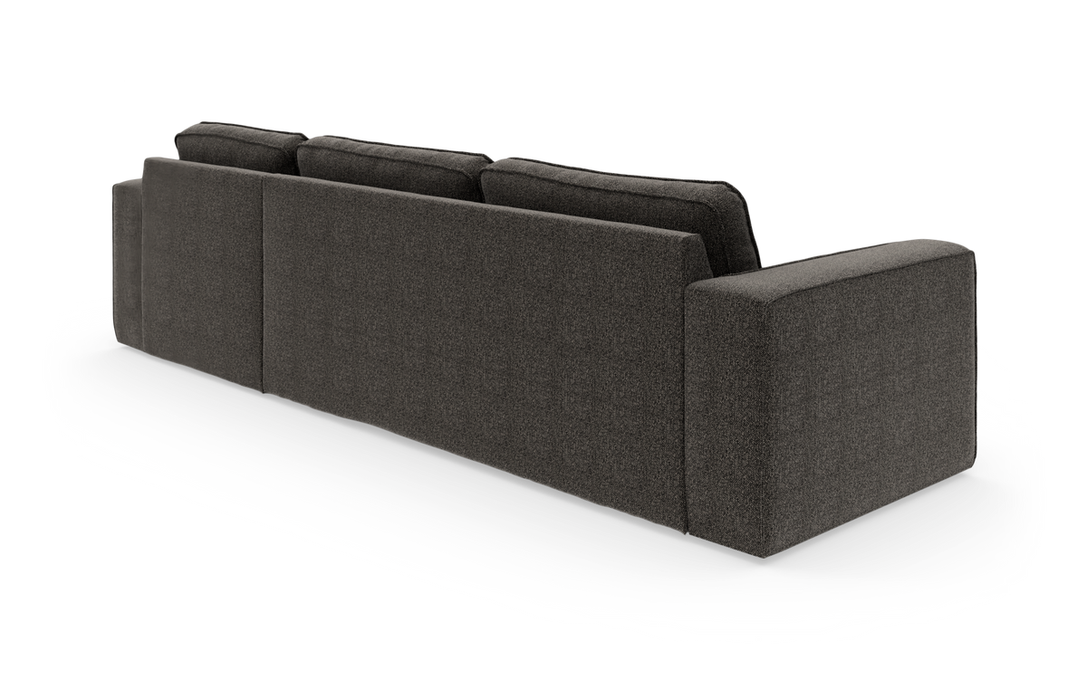 Mørkegrå sofa med tre rygpuder set skråt bagfra, frilagt mod hvid baggrund.