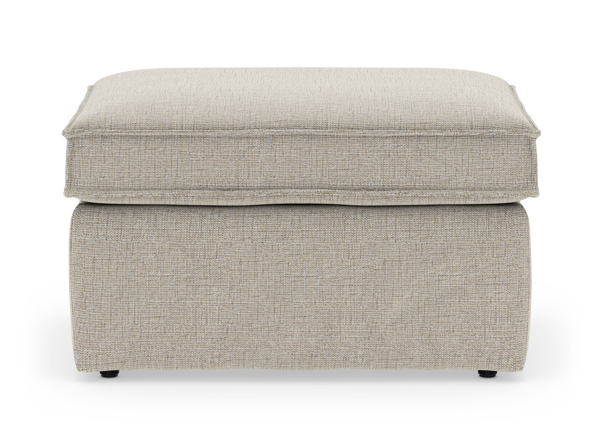 Beige stofbetrukket ottoman/fodskammel med blød pudetop, frilagt på hvid baggrund.
