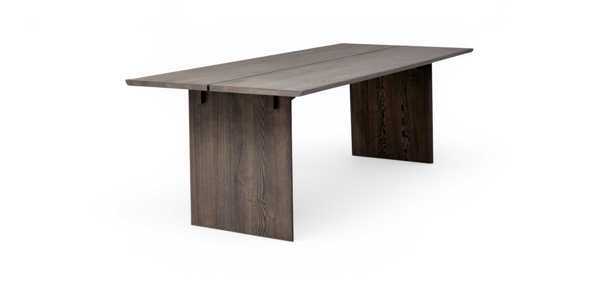 Mørkbejset spisebord i træ med plankeret bordplade og to pladeben i minimalistisk design, fritlagt på hvid baggrund.