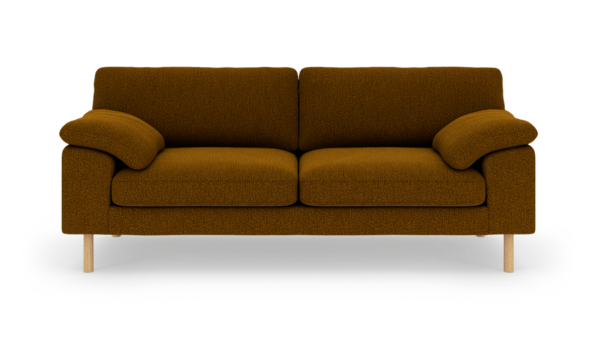 Brun sennepsfarvet 3-personers sofa med bløde armlæn og lyse træben, frilagt på hvid baggrund.