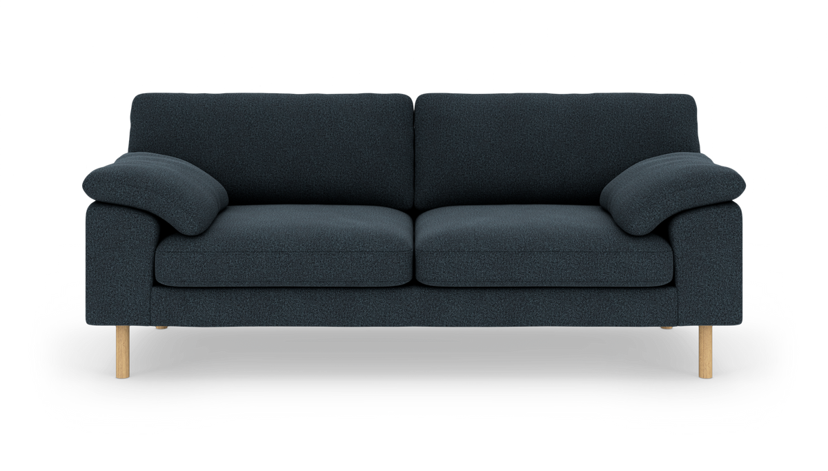 Mørkeblå tresæders sofa med bløde, afrundede armlæn og lyse træben, set forfra.
