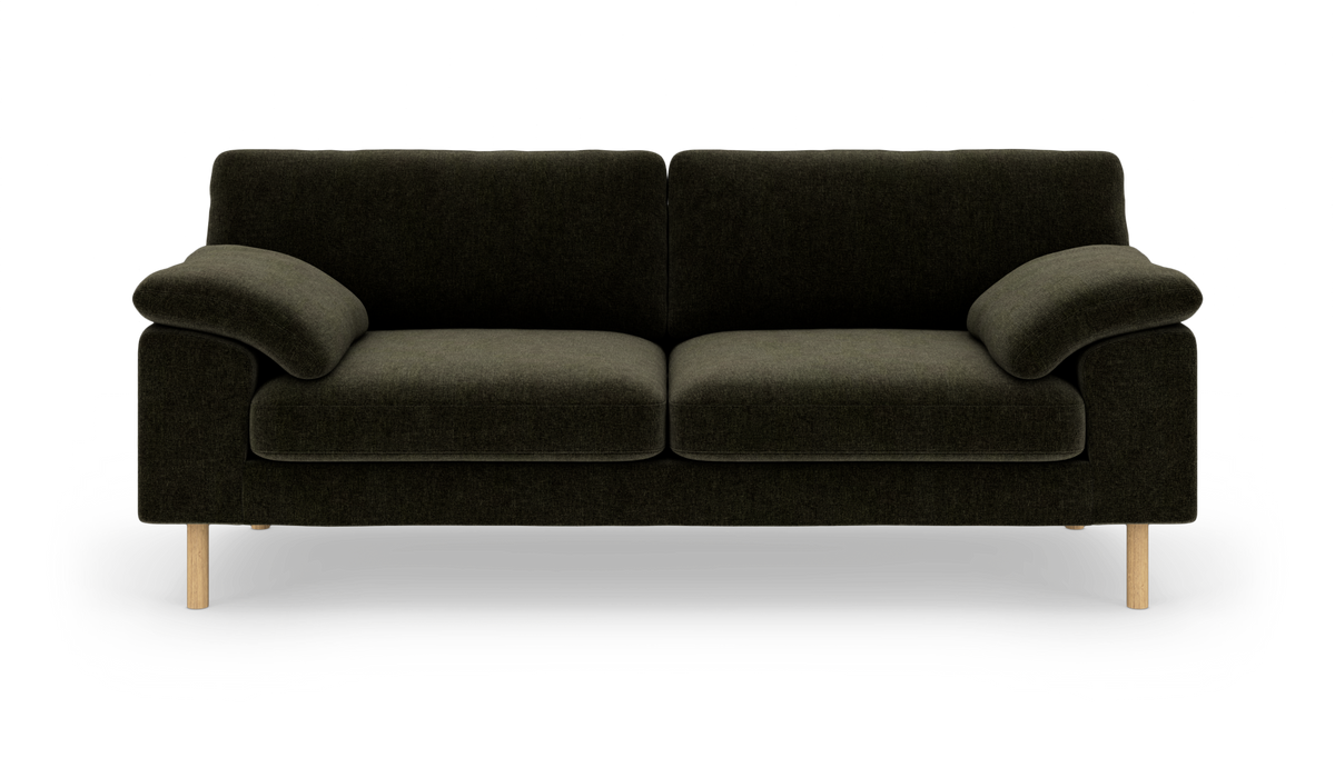 Mørkegrøn to-personers sofa med træben, fotograferet lige forfra på hvid baggrund.