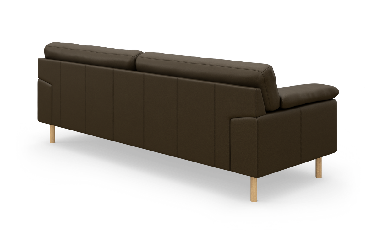 Brun lædersofa med træben, vist skråt bagfra på hvid baggrund.