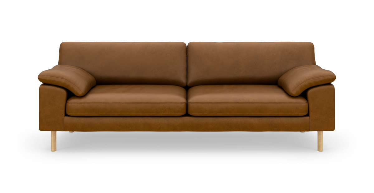 Brun lædersofa med tre sæder, frontvisning, træben og bløde armlæn på hvid baggrund.