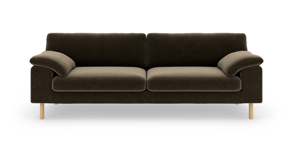 Mørkebrun stofsofa med tre pladser, afrundede pude-armlæn og lyse runde træben, set lige forfra mod hvid baggrund.