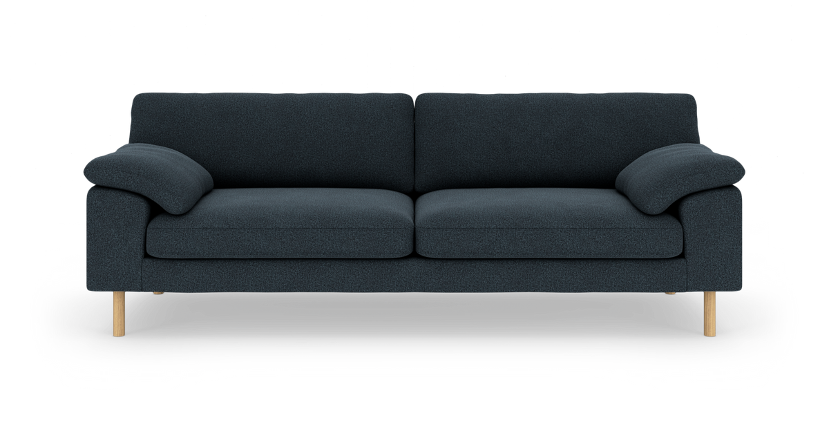 Mørkeblå tresæders sofa med afrundede armlæn og lyse træben, set forfra.