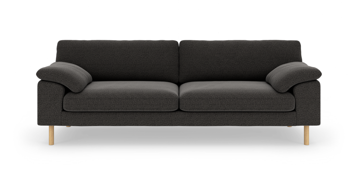 Mørkegrå tresæders sofa med afrundede armlæn og lyse træben, set forfra.