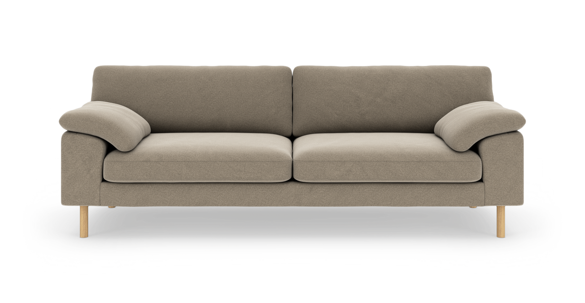Beige 3-personers stofsofa med bløde, afrundede armlæn og træben, fotograferet lige forfra på hvid baggrund.