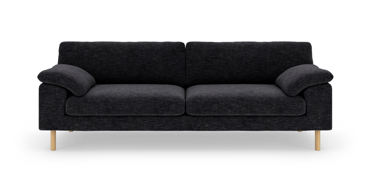 Mørkegrå sofa med to siddepuder, bløde armlæn og lyse træben, frilagt på hvid baggrund.
