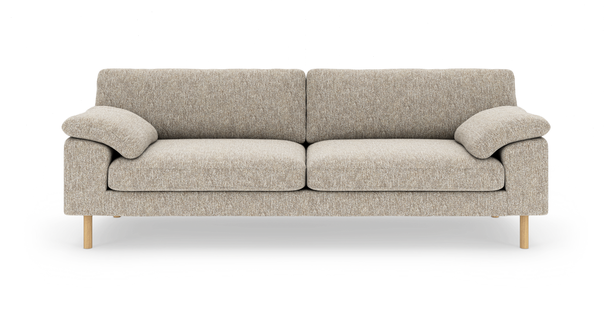Beige 3-personers sofa i stof med to sædehynder, to ryghynder og bløde armlæn, træben, fotograferet lige forfra på hvid baggrund.