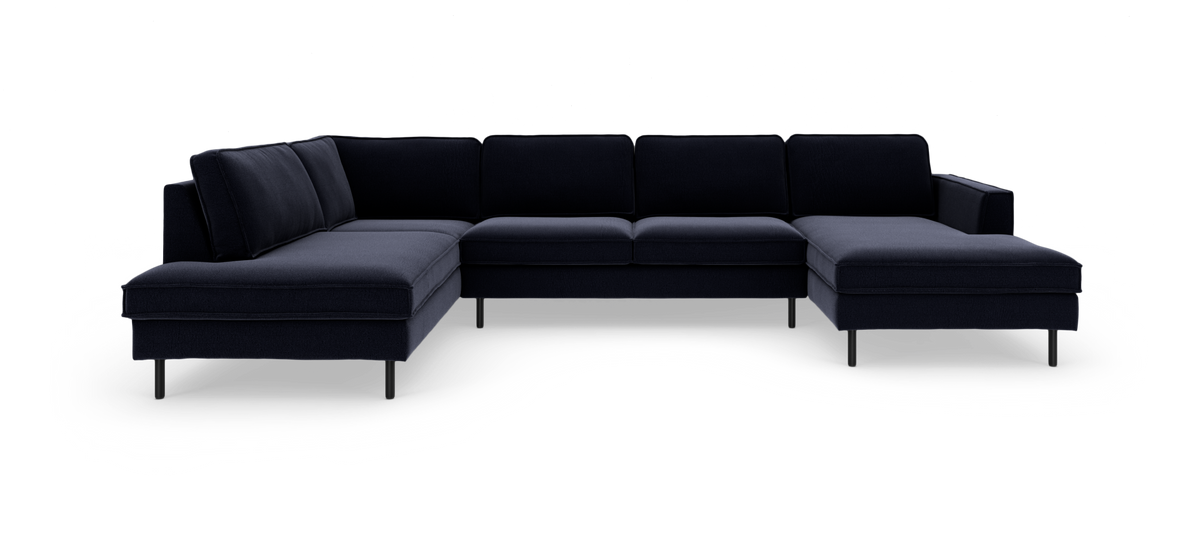 Mørkeblå modulsofa i U‑form med chaiselong i begge ender og slanke metalben.