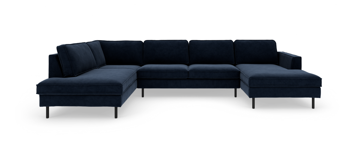 Mørkeblå U‑sofa i stof med chaiselong i begge ender og slanke metalben, frilagt på hvid baggrund.