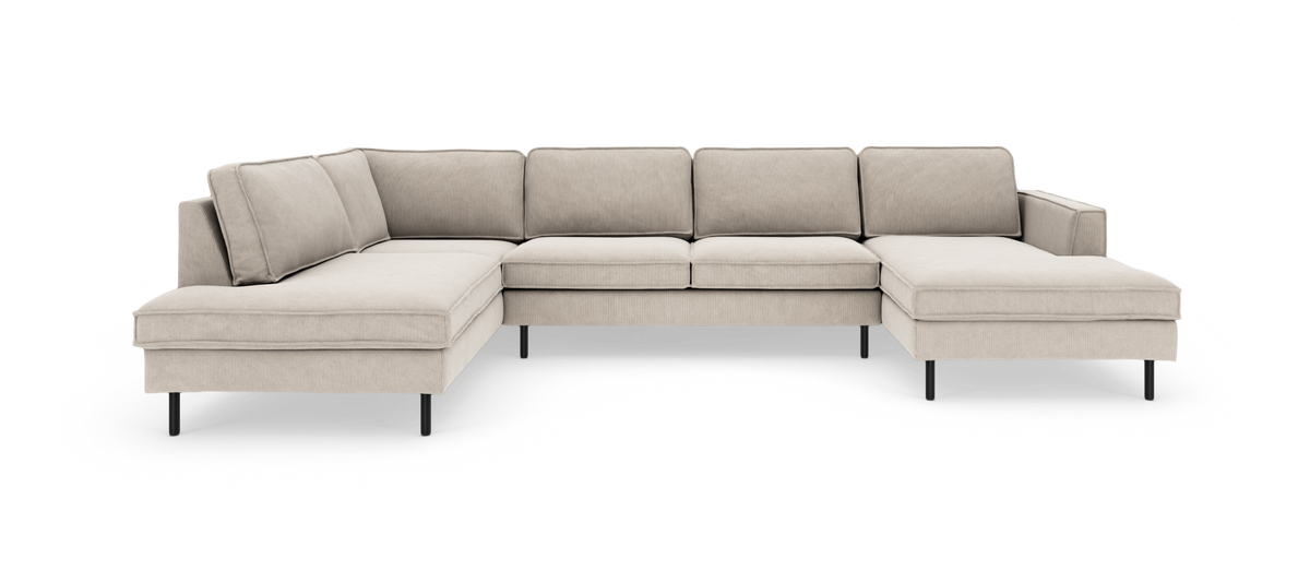 Beige U-formet modulsofa med chaiselong i begge ender og slanke sorte ben, frilagt mod hvid baggrund.