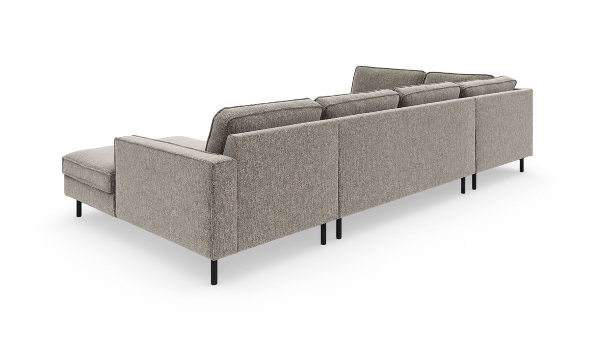 Modulsofa i grå/beige stof, vist bagfra i vinkel med slanke sorte ben på hvid baggrund.