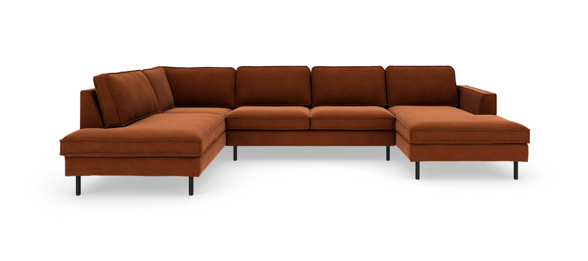 Stor moderne modulsofa i U‑form med chaiselonger i begge ender, rustfarvet polstring og sorte ben, frilagt på hvid baggrund.