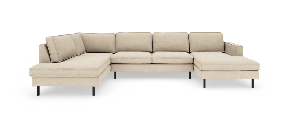 Beige modulsofa i U‑form med chaiselong i begge ender og slanke sorte ben.