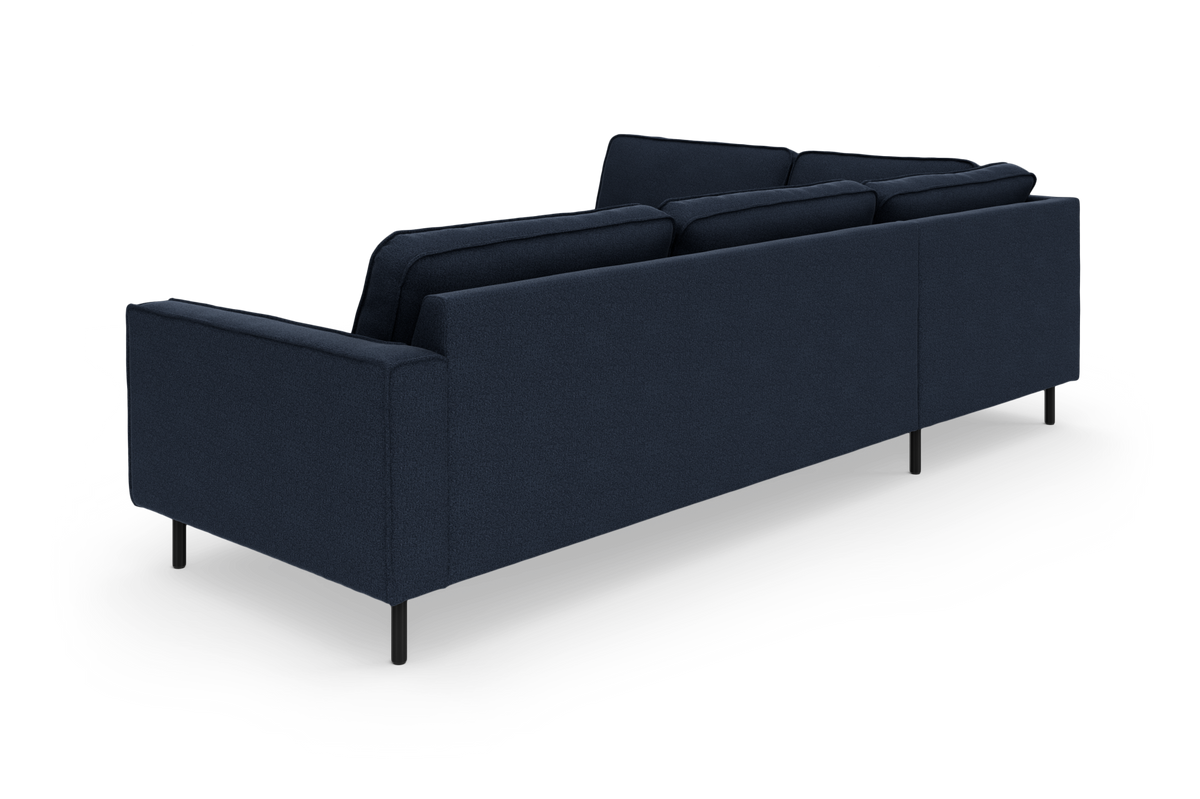 Mørkeblå sofa set bagfra med slanke sorte ben, frilagt på hvid baggrund.