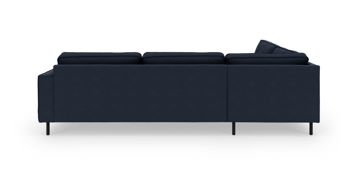 Mørkeblå modul-/hjørnesofa med chaiselong til højre set bagfra på hvid baggrund.