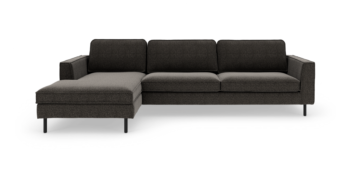 Mørkegrå hjørnesofa med venstrevendt chaiselong, slanke sorte ben og lige armlæn, frilagt på hvid baggrund.