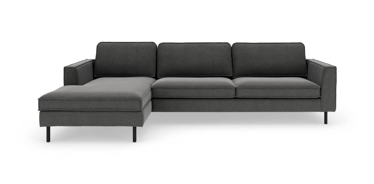 Mørkegrå modulsofa med venstrevendt chaiselong og slanke sorte ben, frilagt på hvid baggrund.