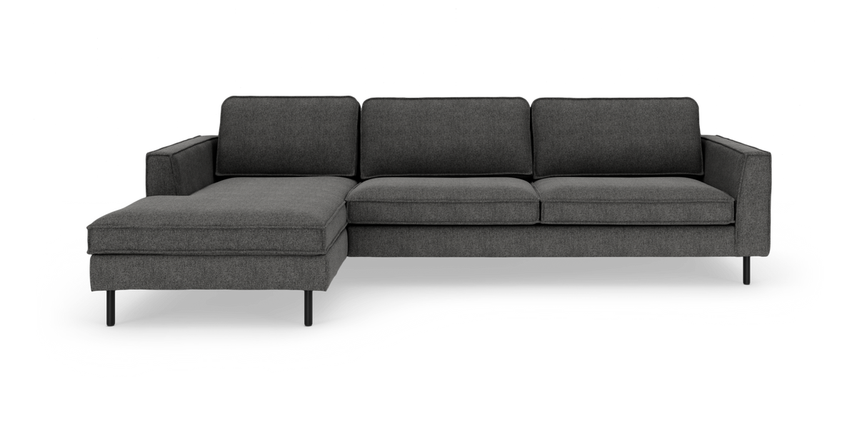Mørkegrå sofa med venstre chaiselong, slanke sorte ben og moderne, minimalistisk design, frilagt på hvid baggrund.